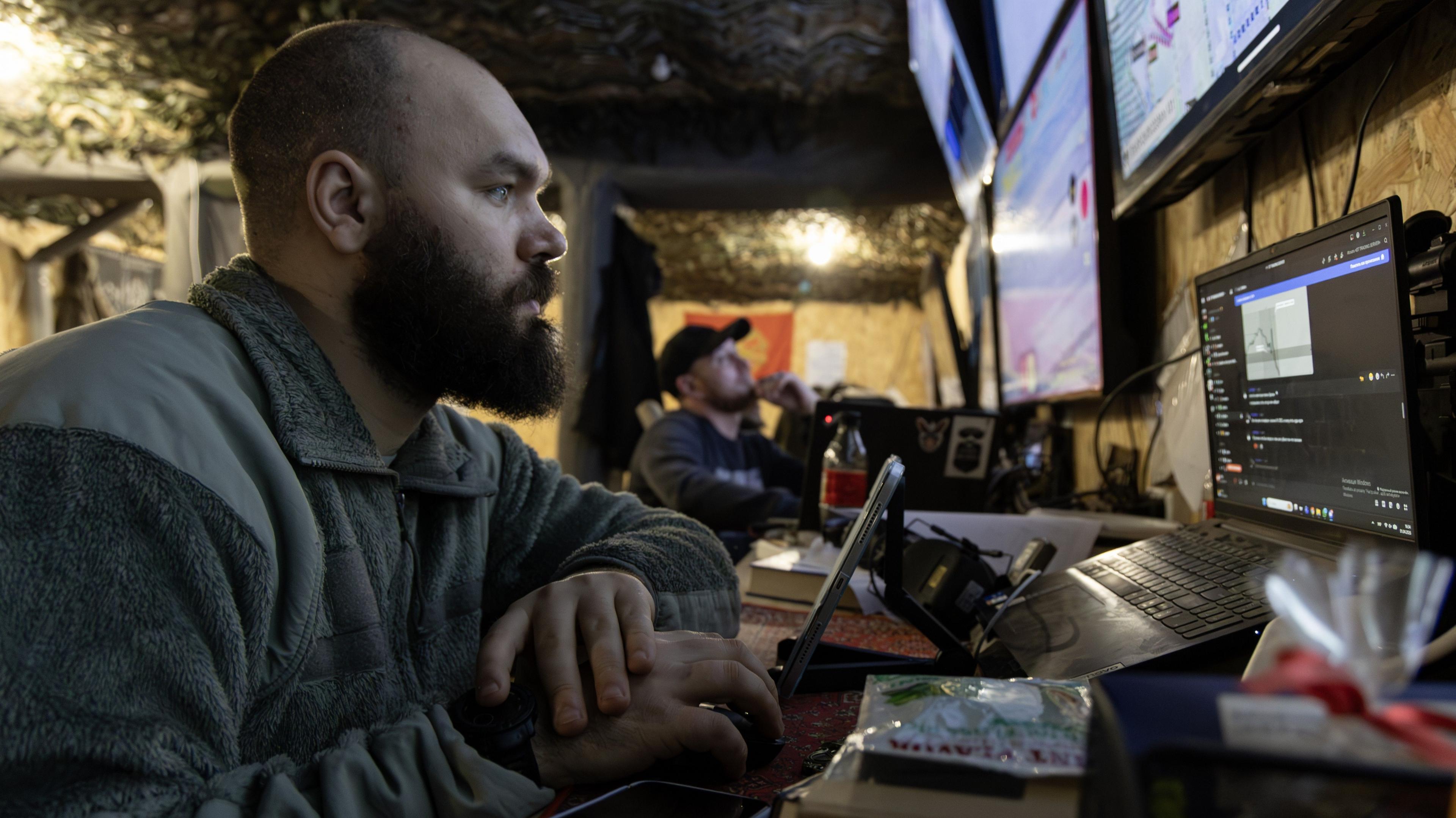 Ukrainian soldier surrounded by computer screens with Starlink equipment
