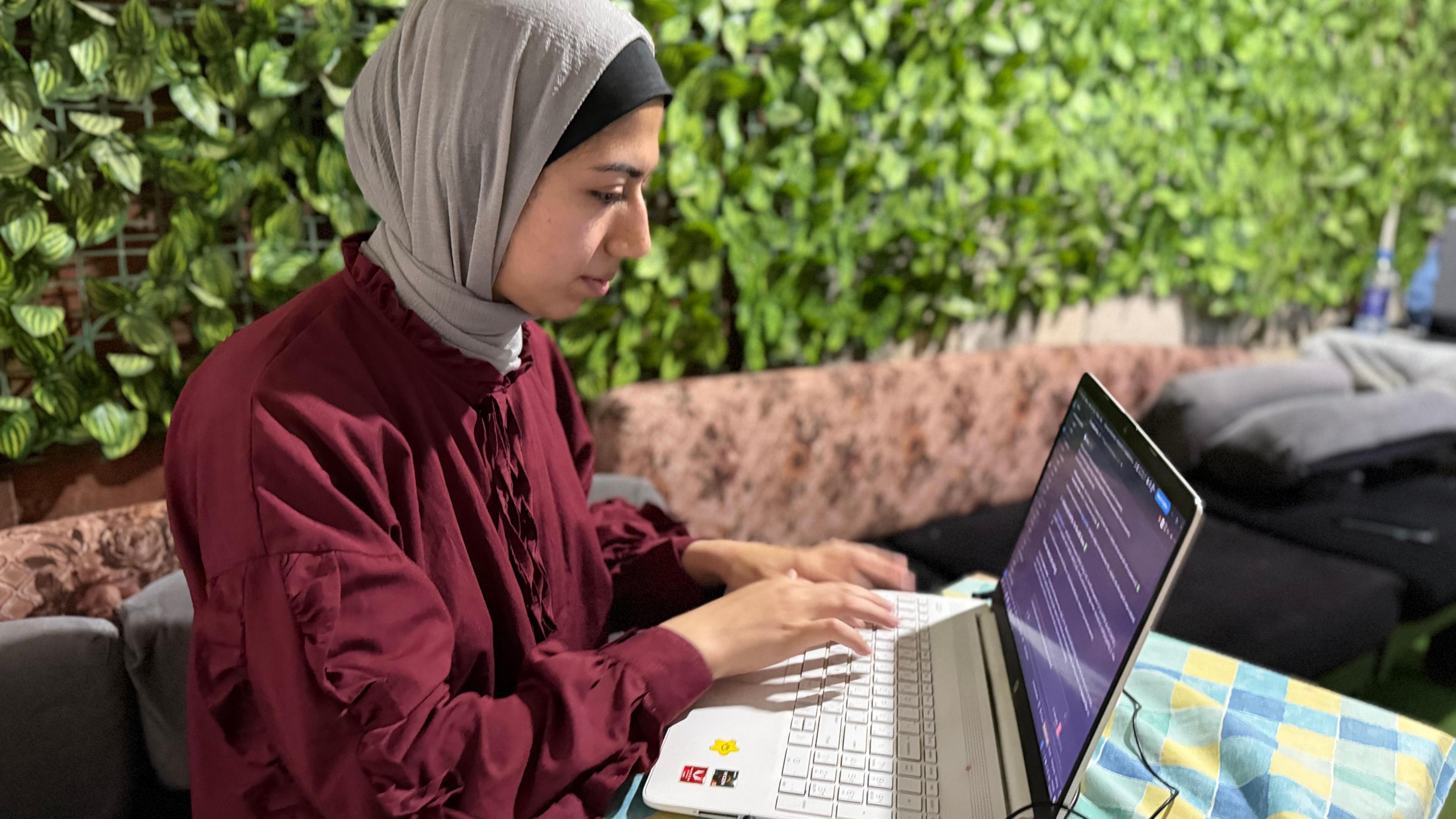 Walaa Volidis, a Palestinian software engineer, works on her laptop