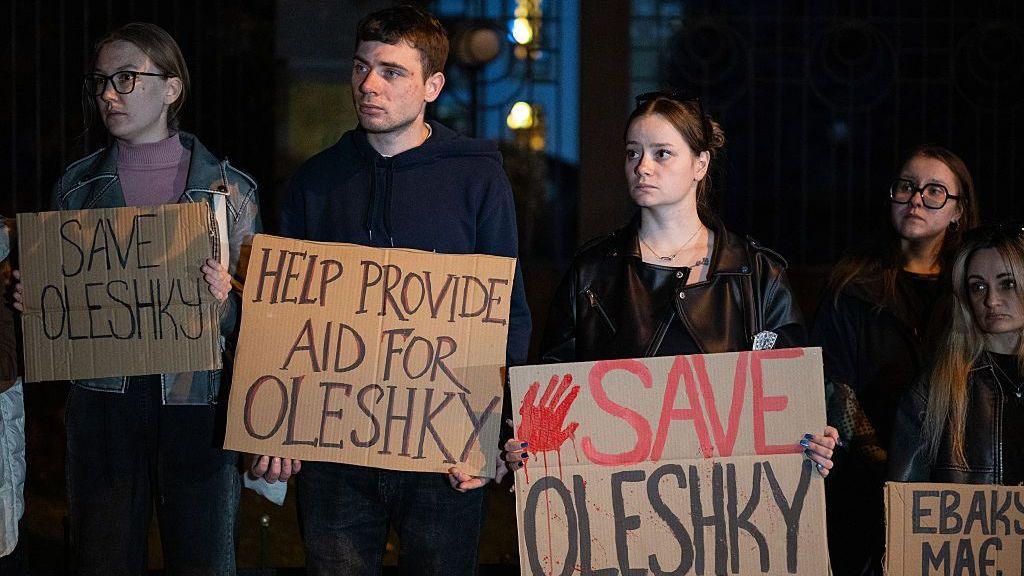 Activists hold placards in Oleshky