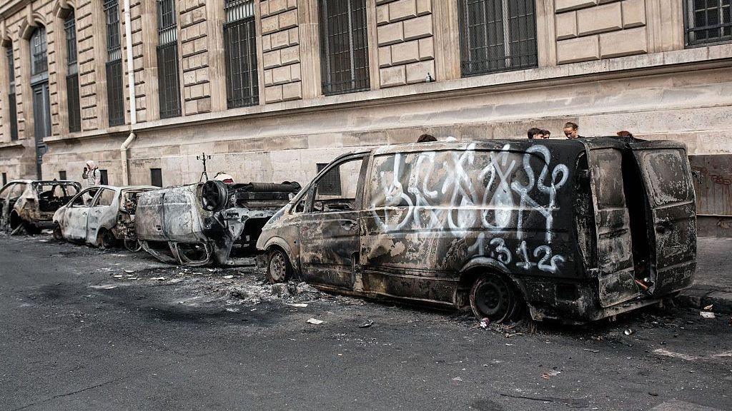 Burned out vehicles and overturned car on a Paris street after rioting