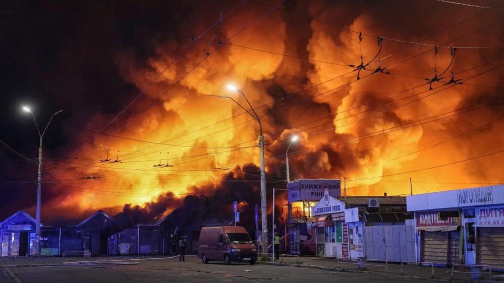 Firefighters work at the site of a book market hit by a Russian missile strike in Kyiv