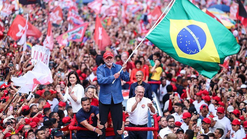 Lula waving the Brazil flag during a rally
